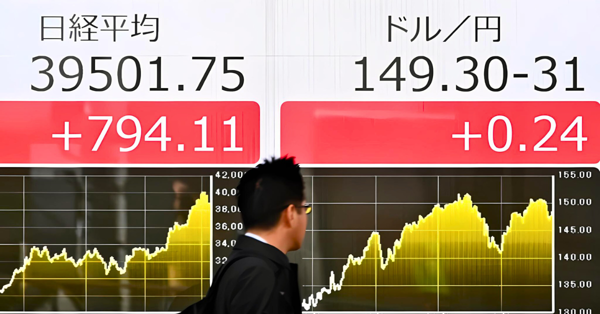A man walks past a stock quotation board.
Image Source: Arab News
